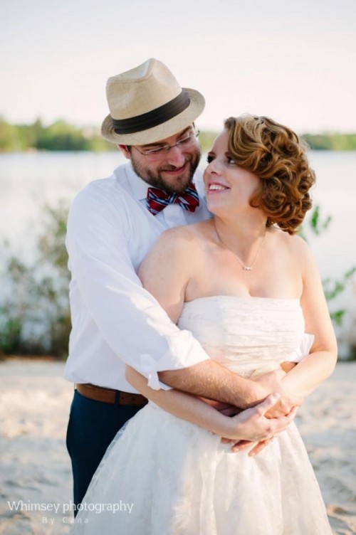 navy pants, a white shirt, a colorful striped tie and a hat for a dapper beach groom's outfit