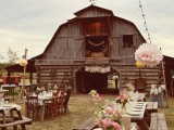 a cool outdoor barn wedding reception space with pink floral arrangements, neutral textiles and neutral porcelain is very cool and chic