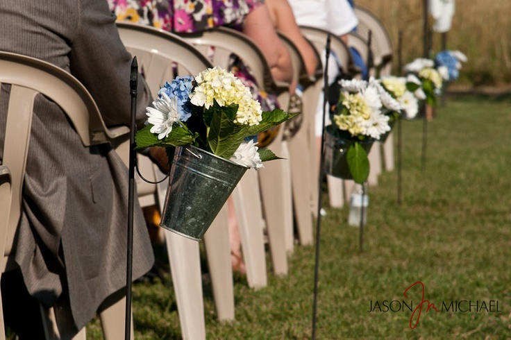 Buckets with bold floral arrrangements are great to line up the aisle of an outdoor barn wedding reception