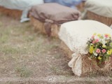 an outdoor rustic space with hay and covers and bold blooms is a lovely idea for a wedding ceremony space