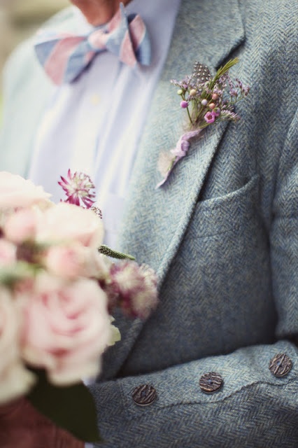 a stylish groom's look with a grey tweed suit, a white button down and a colorful bow tie plus a florla boutonniere