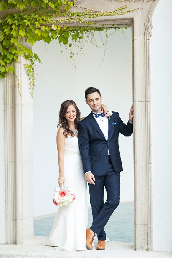 a catchy groom's look with a navy suit, a white button down, amber shoes and a printed bow tie