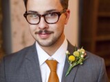 a vintage groom’s look with a grey suit, a white button down and a rust tie plus a billy ball boutonniere