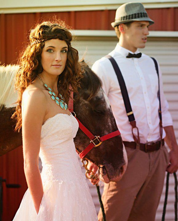 a vintage groom's look with tan pants, a white shirt, black suspenders, a black bow tie and a grey hat