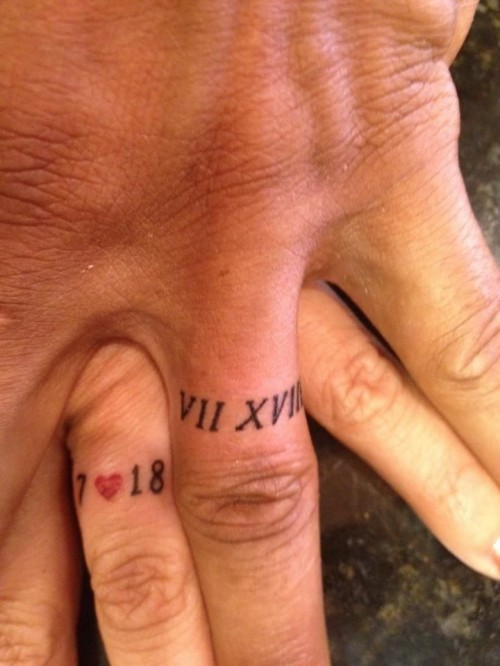 mismatching wedding date tattoos done with Roman and usual numbers, with a tiny heart instead of usual wedding bands