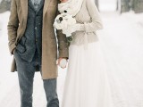 a grey tweed suit, a grey button down and a printed tie plus a beige coat for a snowy wedding day