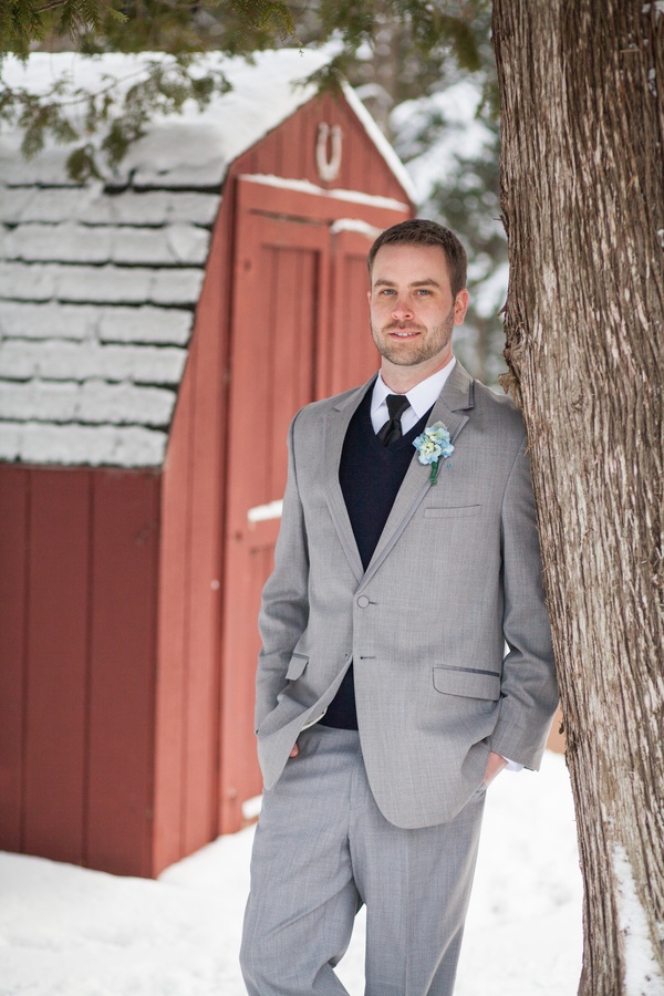 a grey suit, a black jumper over the shirt, a black tie and a white button down for an elegant and chic winter groom's look
