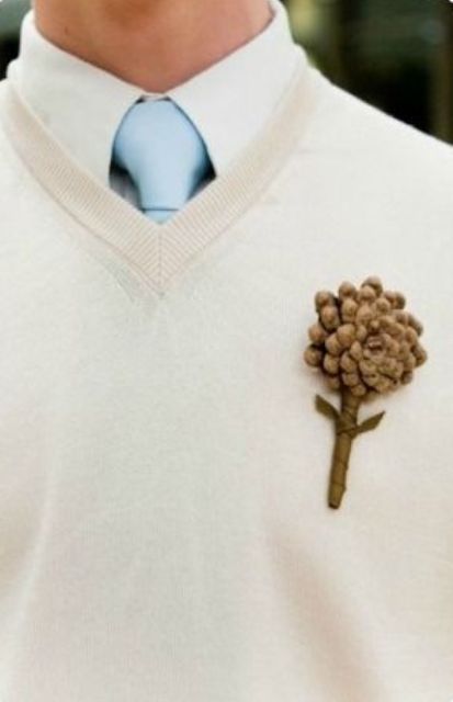 a simple and casual look with a white shirt, a blue tie, a creamy jumper and a pinecone boutonniere