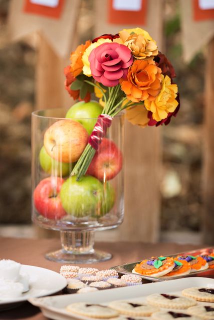 a cute fall bridal shower centerpiece of apples and a bright blooms arragement