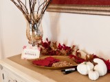 a fall bridal shower station decorated with burlap, pumpkins and bright paper leaves