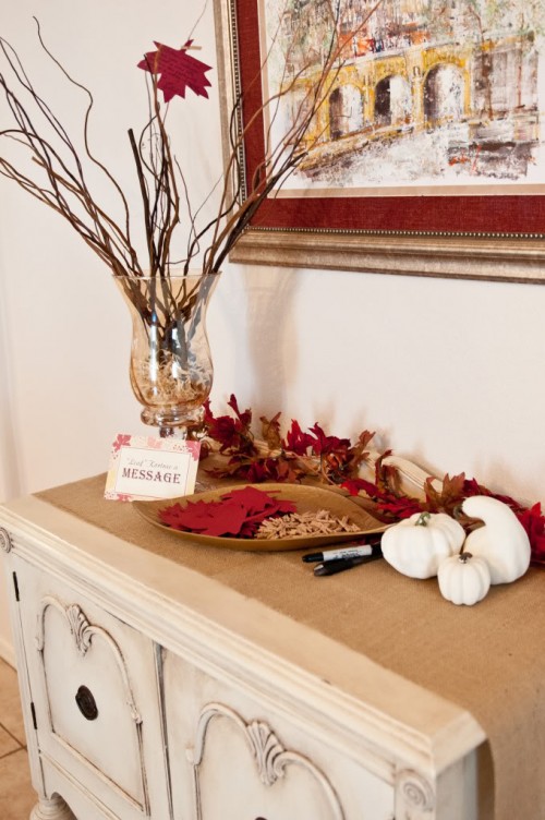 a fall bridal shower station decorated with burlap, pumpkins and bright paper leaves
