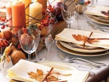 a chic fall bridal shower tablescape with a neutral tablecloth, a cool centerpiece of faux pumpkins, pinecones, gourds, candles and fall leaves
