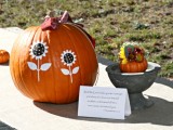 an orange pumpkin with painted sunflowers is a cool fall bridal shower decoration or centerpiece