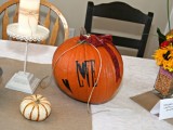 an orange pumpkin with letters, ribbons and painted elements is a great decoration for the shower