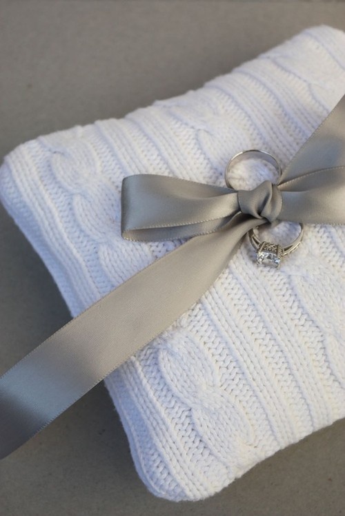 a white knit ring pillow with a traditional sweater pattern and a silk bow is a lovely idea for a winter wedding, you can DIY one