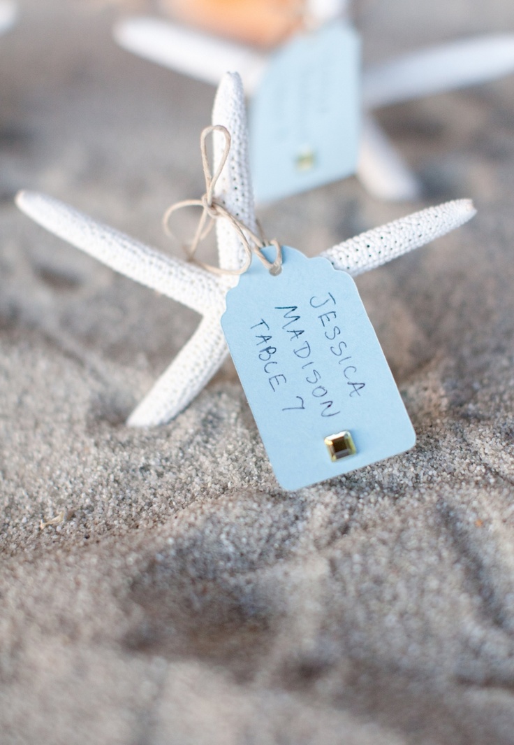 a box with beach sand and starfish with escort cards is great for a beach or coastal wedding