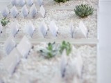 trays with white pebbles, paper cards and some succulents will fit not only a beach wedding but also many others