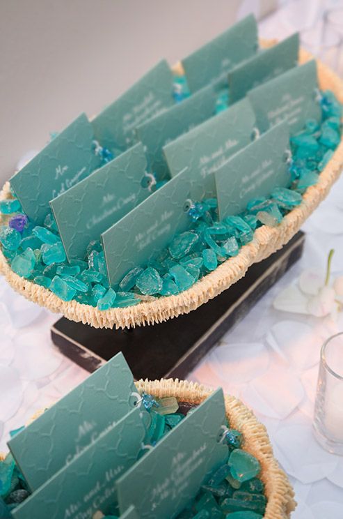 baskets with seaglass and escort cards look chic and bright for a beach or coastal wedding