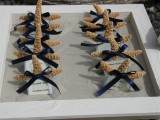 a tray with sand, starfish with ribbon bows and escort cards is a simple option to display escort cards for a nautical wedding