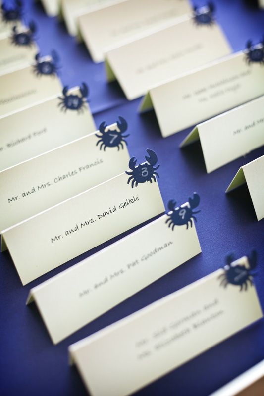 a purple tray with escort cards and little crabs is a stylish and simple DIY for a beach wedding