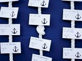 a navy backdrop with rope with knots and nautical cards with anchors is a bold and contrasting way to go for