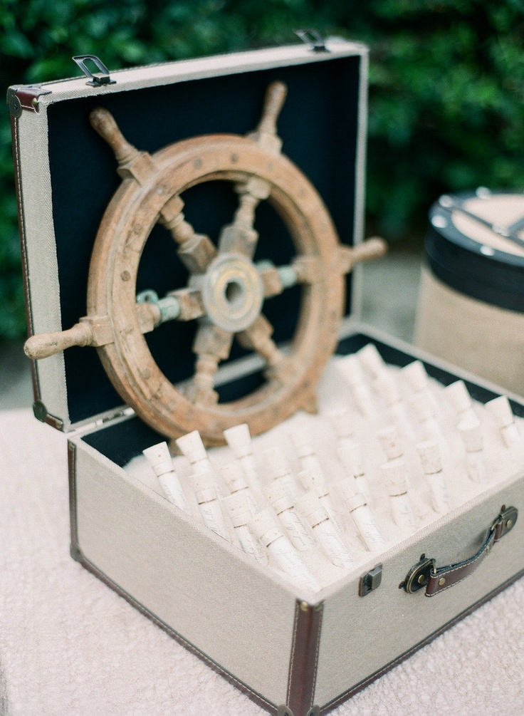 a box with beach sand, escort cards in test tubes and a steering wheel for a nautical wedding