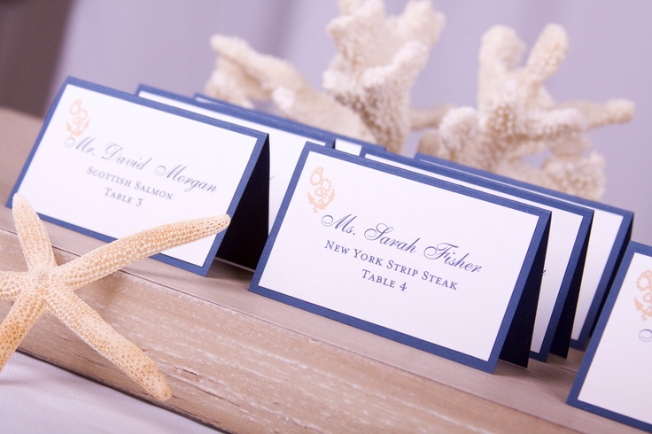 a wooden tray with navy and white escort cards and starfish is a cool idea to rock at a nautical or beach wedding