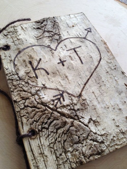 a large piece of bark with a cutout heart is a cool idea for a rustic wedding guest book
