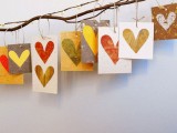 a branch with colorful hearts on paper pieces is a chic and fun idea of a fall wedding guest book