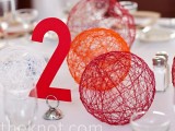 red and orange yarn spheres and a table number can be easily DIYed