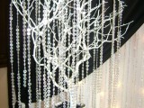 white branches in an embellished jar and long hanging crystal strands for a glam feel