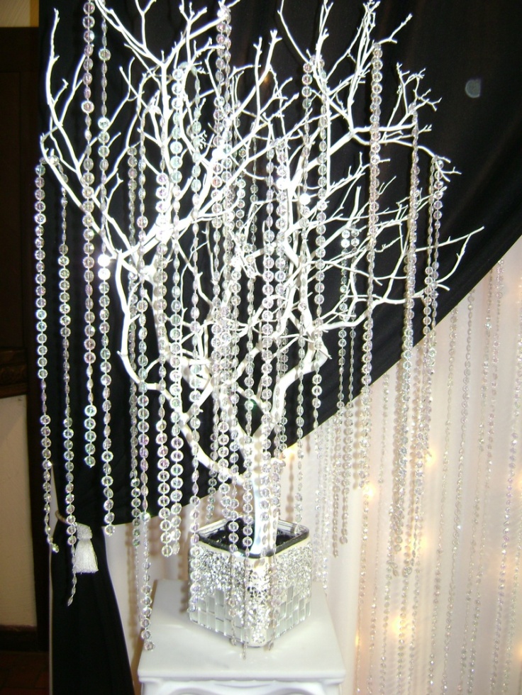 White branches in an embellished jar and long hanging crystal strands for a glam feel