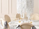 an overhead white faux blooms centerpiece will save the table space, and matching garlands on the chairs will help