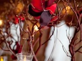red branches with hanging candle lanterns and red fake blooms on them
