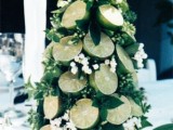 a greenery and lime wedding centerpiece shaped as a Christmas tree