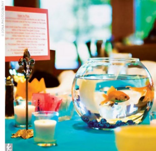 an aquarium with gold fish and blue pebbles is a cool idea with a living feel