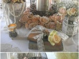 a vintage cage with pilalr candles, feathers, pearl strands and fake blooms for a vintage-inspired wedding