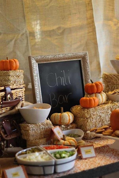 a cozy fall wedding salad bar decorated with hay, faux pumpkins and chalkboard menus