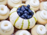 vanilla cupcakes with cream swirls and a fun centerpiece of a pumpkin and blueberries inside