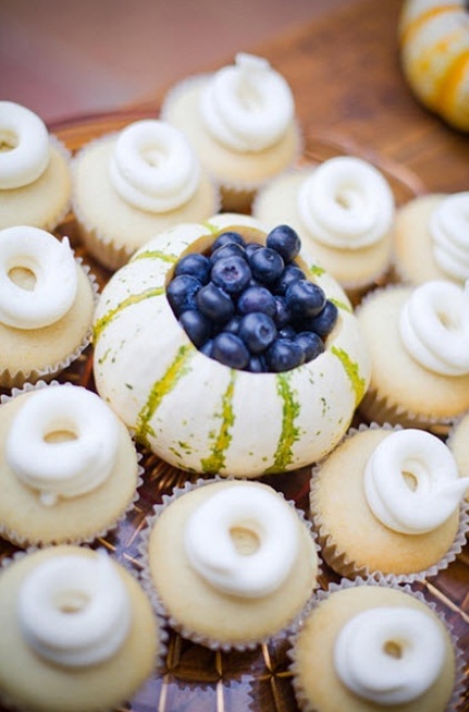 vanilla cupcakes with cream swirls and a fun centerpiece of a pumpkin and blueberries inside
