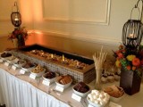 an s’more bar decorated with fall blooms and candle lanterns is a cool idea for fall and winter weddings