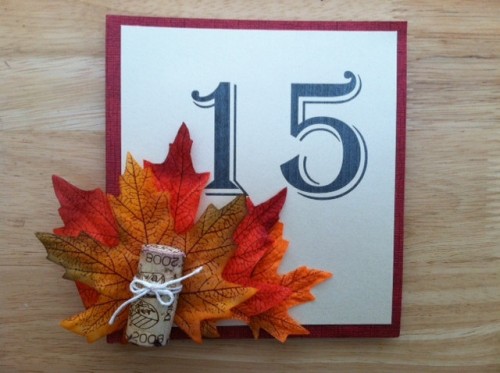 a framed table number, bright fall leaves and a piece of a branch will match a rustic or woodland fall tablescape