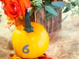 a pumpkin with a table number is always a good addition to a fall centerpiece, especially for a rustic one