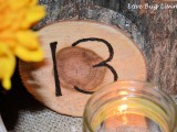 a burnt wood slice with a table number and a candle is a very stylish idea for a rustic fall wedding table setting