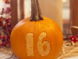 a natural pumpkin with a carved number is a bold and cool farmhouse wedding idea you can make