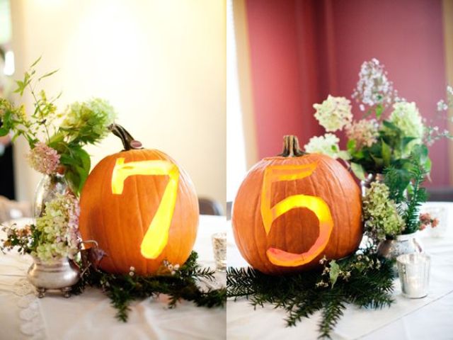 Bright pumpkins with cutout numbers and lights inside placed on fir branches and with blooms look very stylish