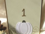 a card with a paper pumpkin and a table number is a perfect fit for a rustic fall centerpeice