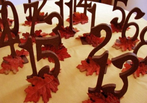 stained wooden table numbers with bright leaves are very bold and will fit a rustic fall tablescape