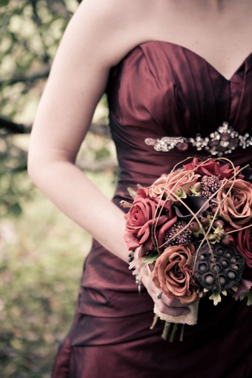 a dark Halloween bouquet with moody blooms, lotus, berries and some twigs is a very creative and bold idea