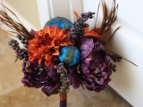a creative Halloween wedding bouquet of purple and orange blooms, berries, dried grasses and blue spheres
